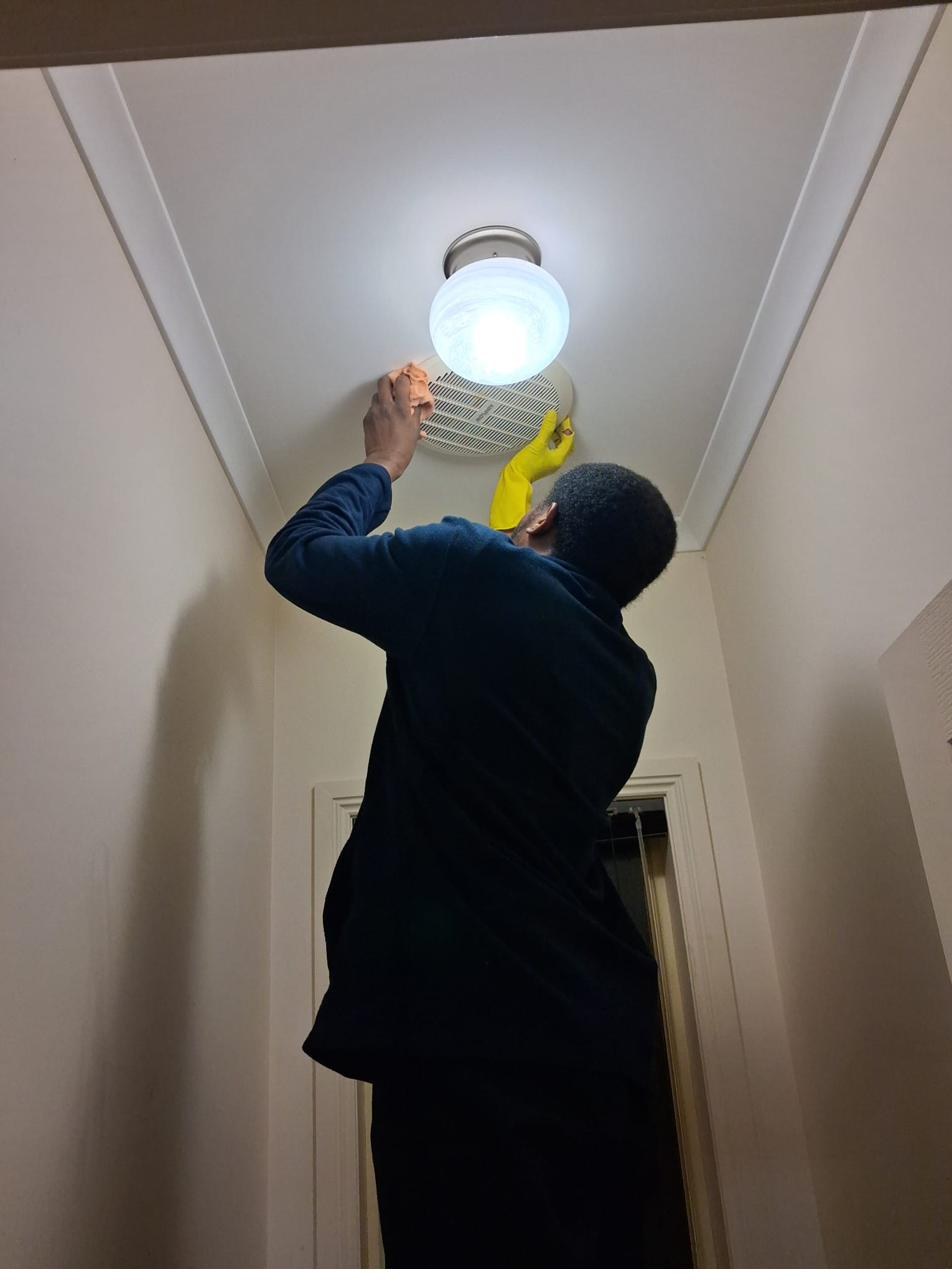 Vine Cleaning team member detailing an air vent and light fitting during an end-of-lease clean